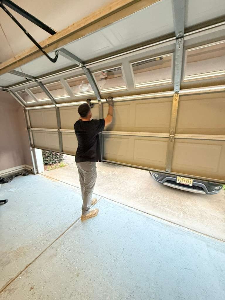 A person beneath a partly raised sectional garage door